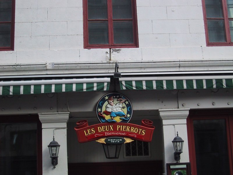 Монреаль, 2004: вывеска «Les Deux Pierrots» у входа в заведение с зелёно-белой шторкой