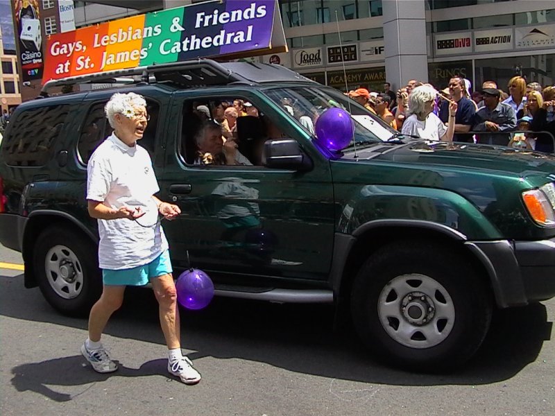 Pride Parade в Канаде, 27 июня 2004: зелёный внедорожник с флагом и фразой «Gays, Lesbians & Friends at St. James' Cathedral»