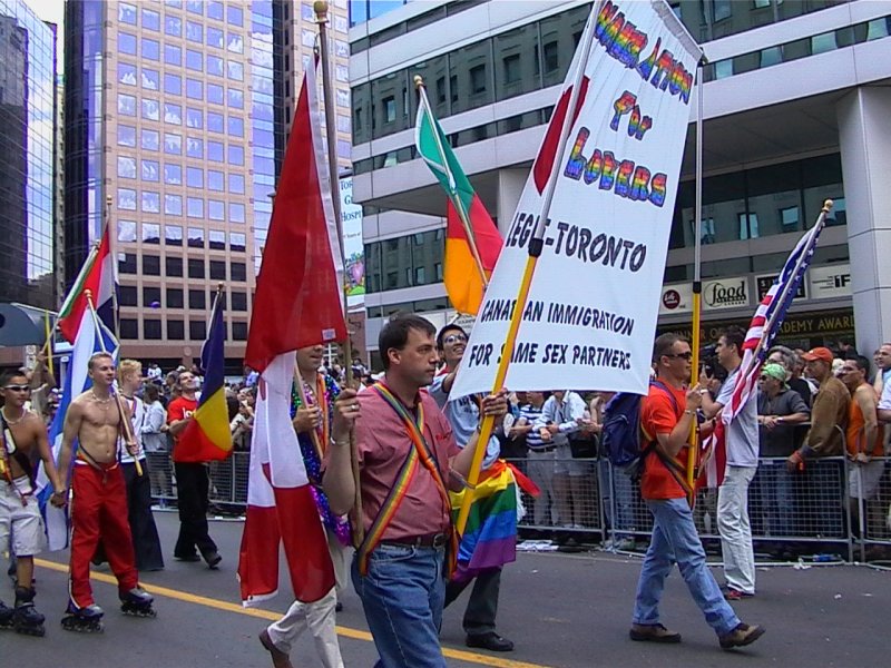 Парад гордости в Торонто, 27 июня 2004: флаги, рюкзаки и плакат о иммиграции для пар