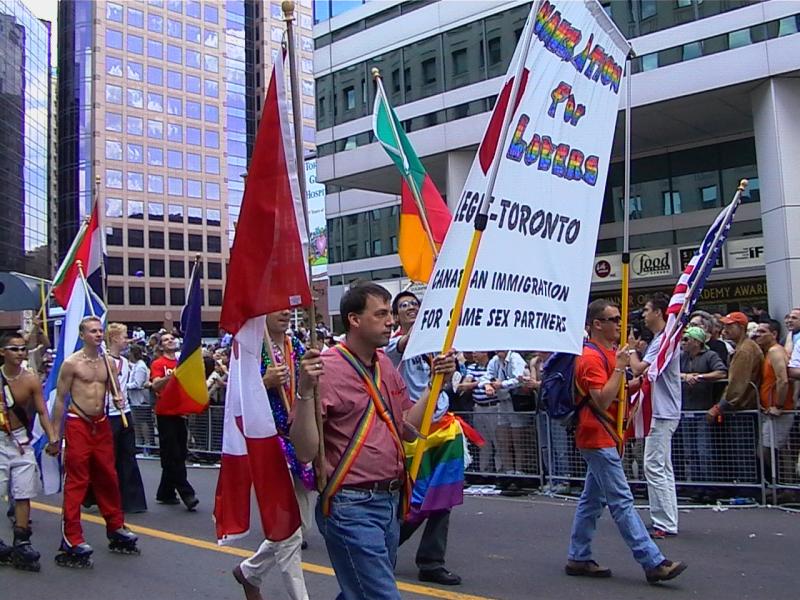 Парад гордости в Торонто, 27 июня 2004: флаги, рюкзаки и плакат о иммиграции для пар
