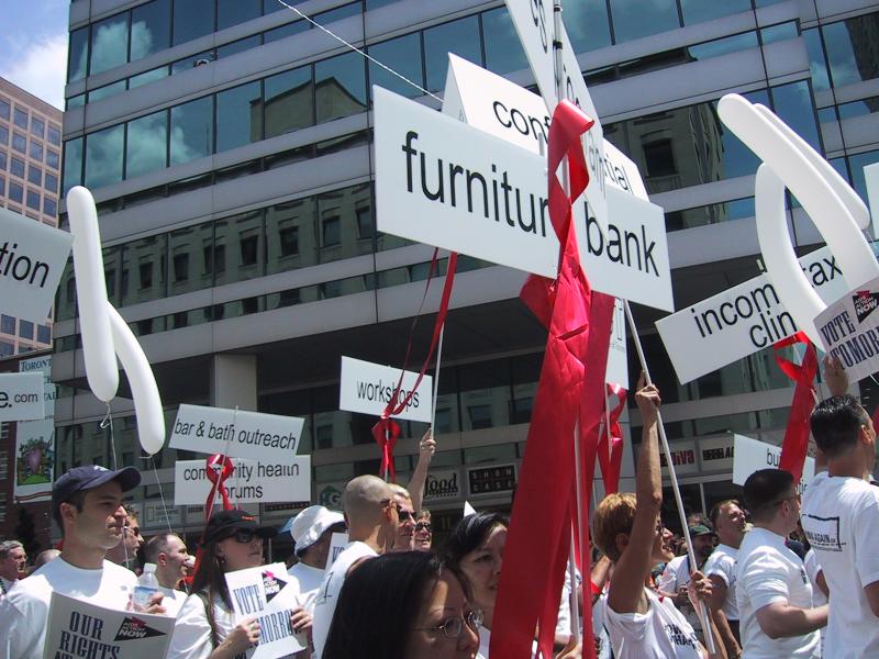 Прайд-парад в Торонто, 27 июня 2004: белые футболки, красные ленты и таблички с «furniture bank»