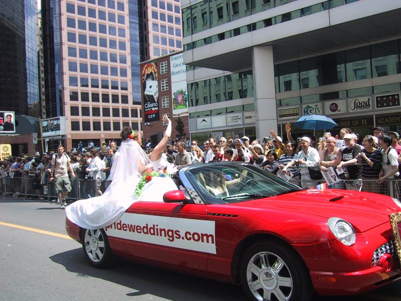 Парад гордости в Торонто, 27 июня 2004: красный форд-трабл с надписью 'prideweddings.com'