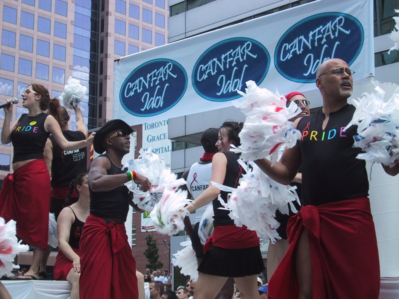 Pride Parade в Торонто, 27 июня 2004: танцующие с помпонами и баннером CANFAR Idol