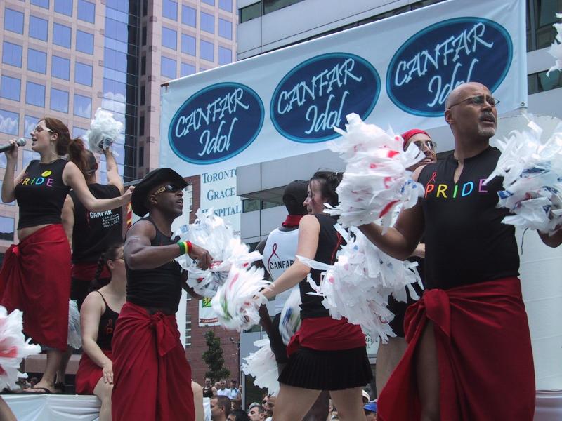 Pride Parade в Торонто, 27 июня 2004: танцующие с помпонами и баннером CANFAR Idol
