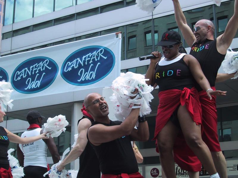 Pride Parade в Канаде, 27 июня 2004: танцующие с помпонами и баннером CANFAR Idol
