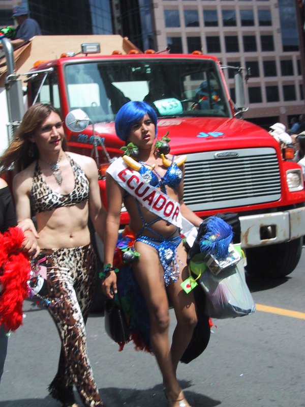 Pride Parade, Toronto, 27 июня 2004: два участника проходят мимо красного грузовика с табличкой «V59»