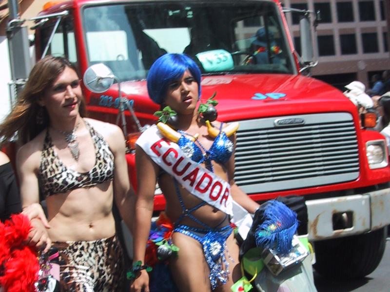 Pride Parade, Toronto, 27 июня 2004: два участника проходят мимо красного грузовика с табличкой «V59»
