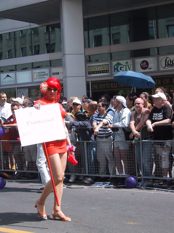 Парад гордости в Торонто, 27 июня 2004: красная фигура с табличкой «Transsexual»