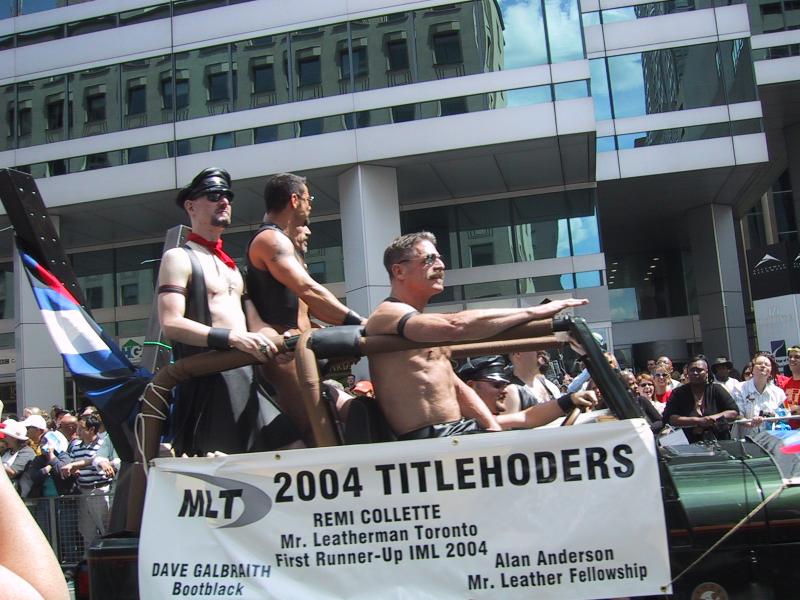 2004, Toronto Pride Parade: «2004 TITLEHOLDERS» на плавучем плоту с флагом и табличкой