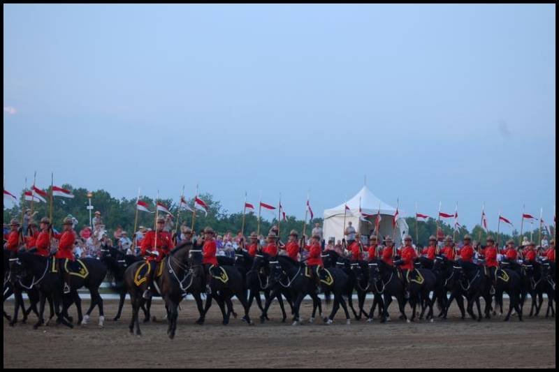 RCMP в красных мундирах на конной парадной стройке в Канаде