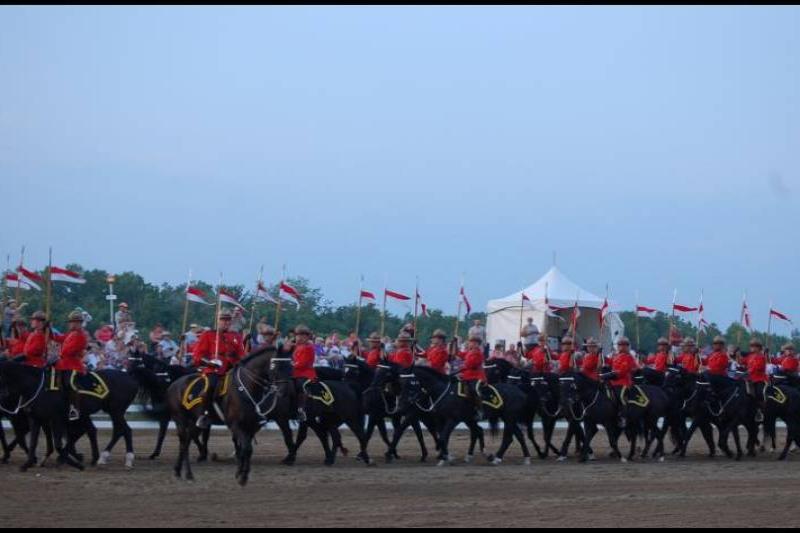 RCMP в красных мундирах на конной парадной стройке в Канаде
