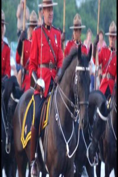 RCMP в красных мундирах на конях у флагов в Канаде