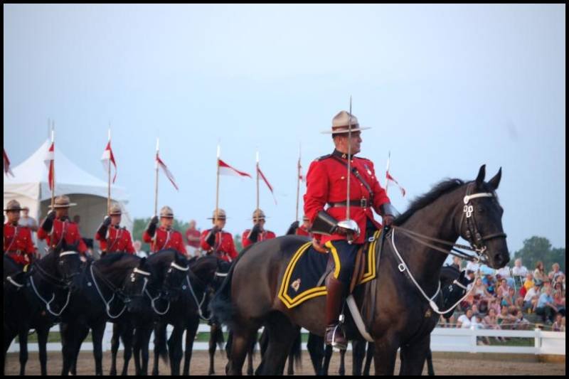 RCMP в красных мундирах и чёрных лошадях на параде в Канаде