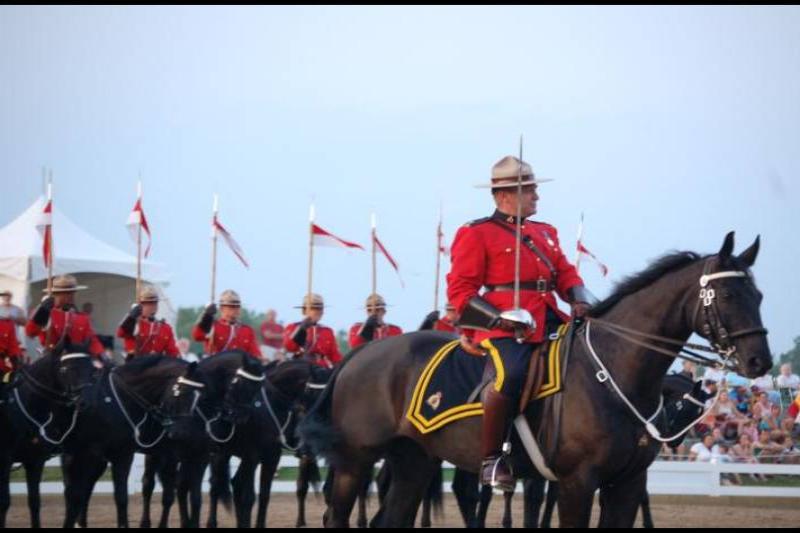 RCMP в красных мундирах и чёрных лошадях на параде в Канаде