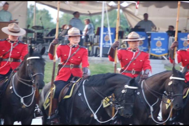 RCMP в красных мундирах на конях у палатки с эмблемой Королевской канадской полиции