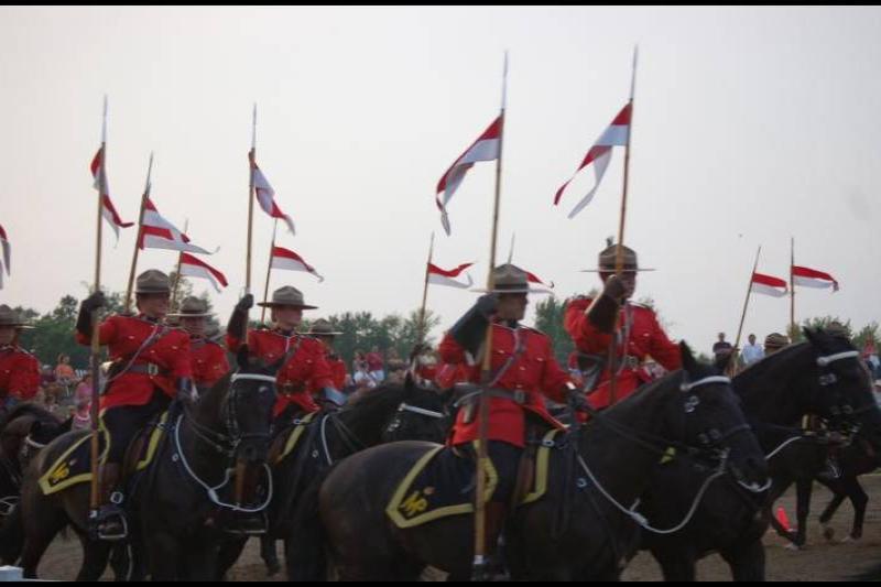 RCMP в красных мундирах на конях с флагами в Канаде