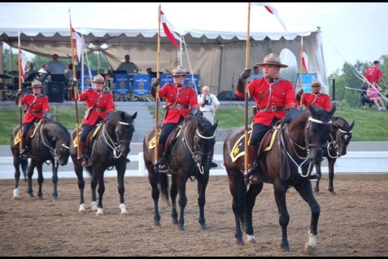RCMP в красных мундирах на конях у палатки в Канаде