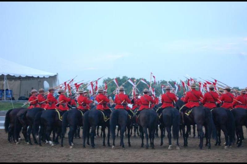 RCMP в красных мундирах на конях у белого шатра в Канаде