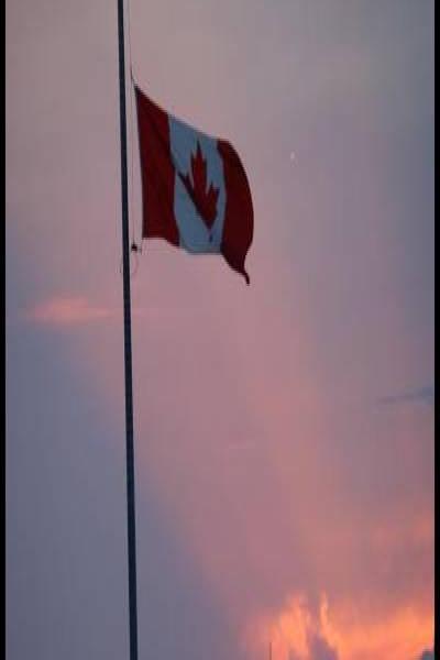 Праздничный вечер в Канаде: флаг и кавалеристы RCMP у фона заката