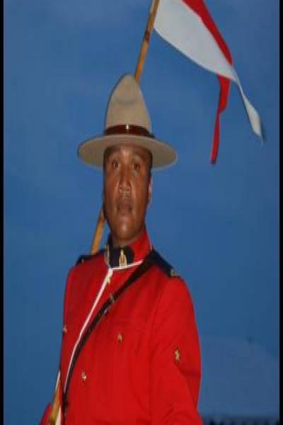 RCMP в красном мундире с флагом на коне в сумерках, Канада