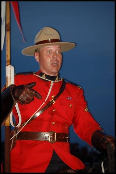 Полицейский в красном мундире RCMP на фоне сумерек