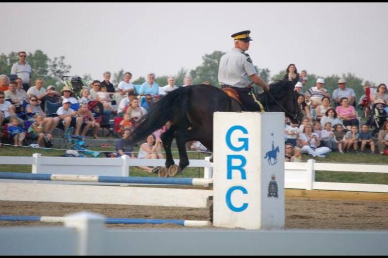RCMP-конный патруль в Канаде: всадник на чёрном коне у барьера GRC