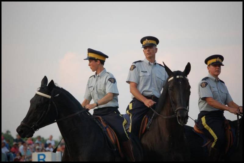 RCMP в форме на конях у стадиона в Канаде
