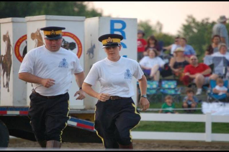 RCMP в движении на фестивале в Канаде: два участника в форме с желтыми полосами
