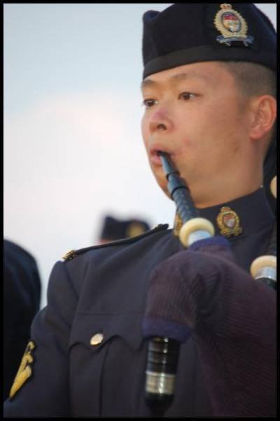 Портрет пайперa в форме RCMP на фоне канадского неба