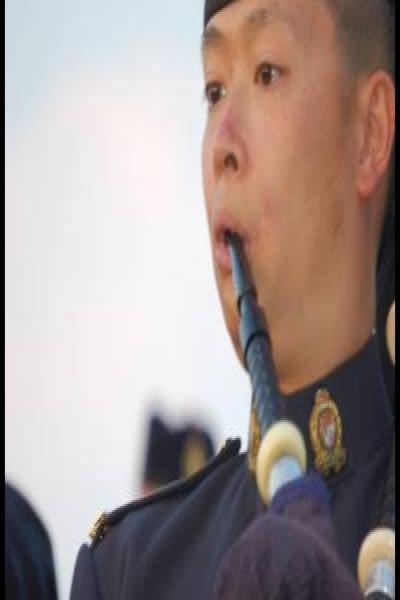 Портрет пайперa в форме RCMP на фоне канадского неба