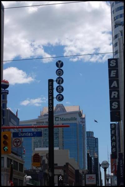 Торонто, 22 июля 2007: улица Дундас и вывеска 'Yonge' над стеклянными небоскрёбами