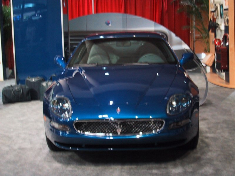 Maserati в зале Toronto Autoshow 2004: синий купе на фоне красных штор