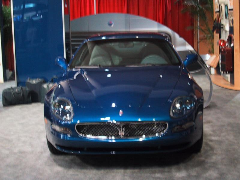 Maserati в зале Toronto Autoshow 2004: синий купе на фоне красных штор
