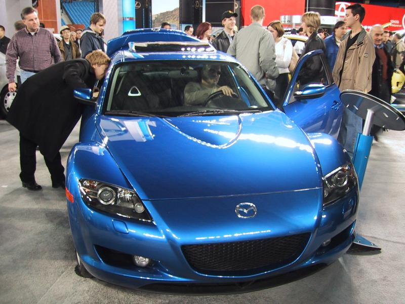 Toronto Autoshow 2004: ярко-синий Mazda RX-8 с открытыми дверями и человеком за рулём