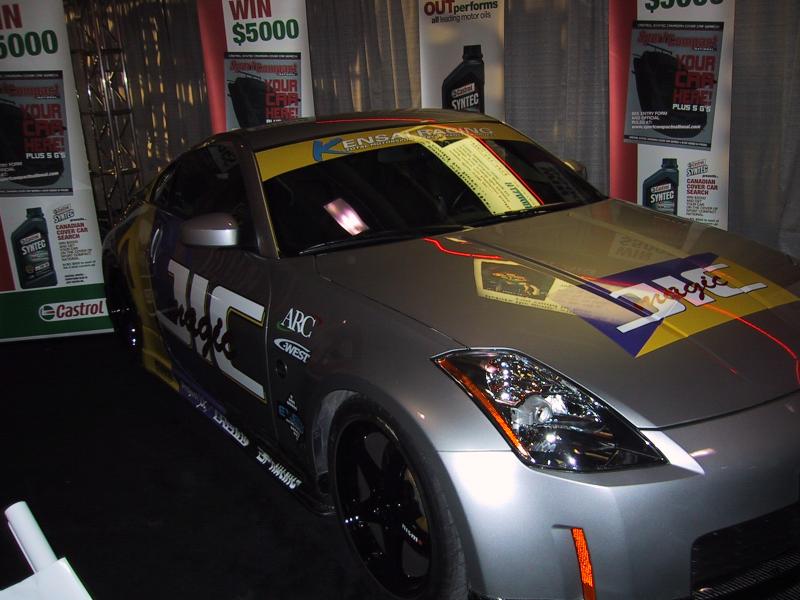 Серебристый спортивный автомобиль Nissan 350Z с рекламными наклейками на выставке