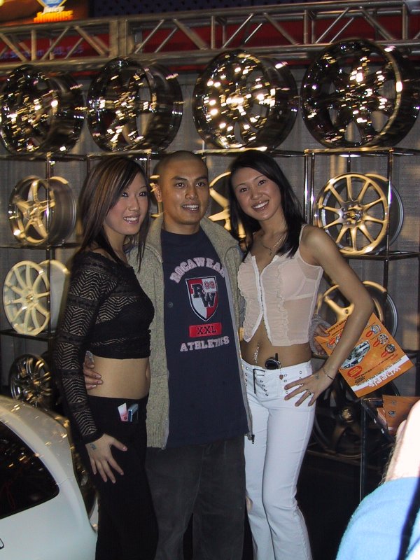 Toronto Autoshow 2004: колёса на стойках, два женщины и мужчина в куртке