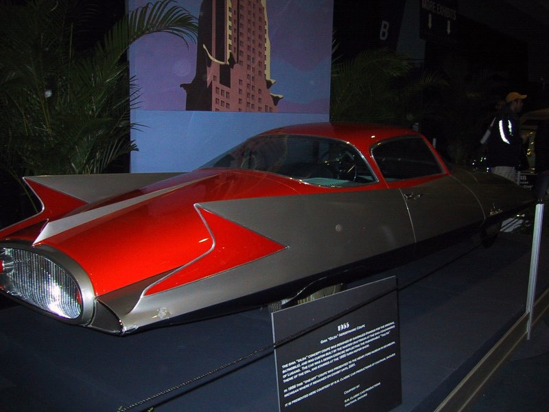 Toronto Autoshow 2004: GMA 'Gilda' Aerodynamic Coupe в зале с пальмами и плакатом небоскрёба