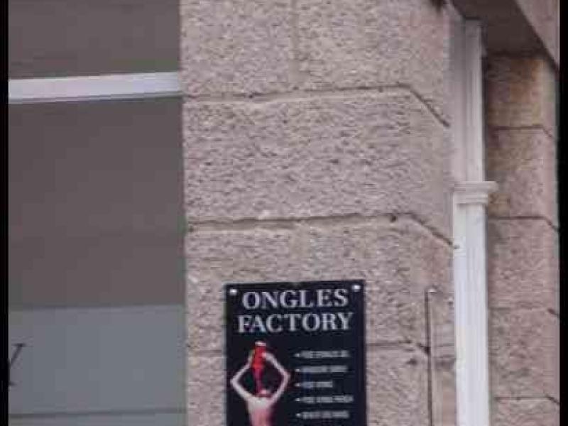 Табличка «Ongles Factory» и указатель «Rue des Marins» на каменной стене здания