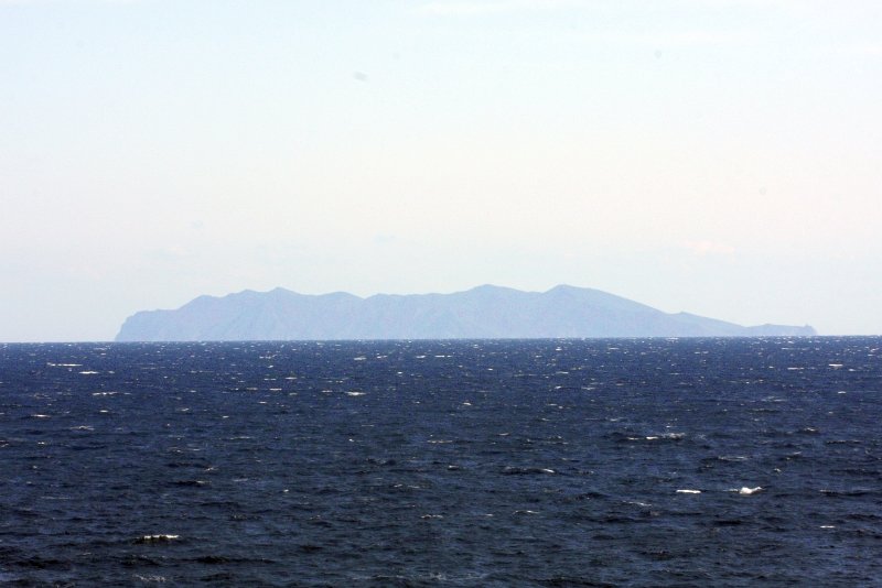 Остров на горизонте над бурным морем в дневное время