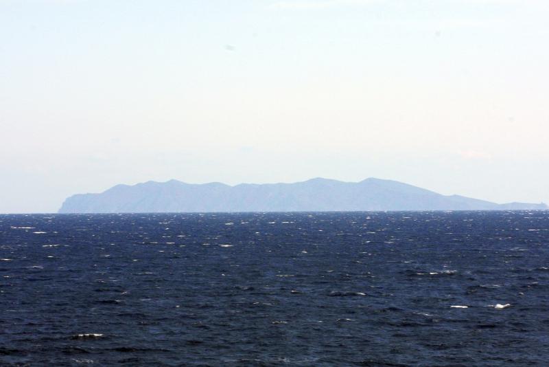 Остров на горизонте над бурным морем в дневное время