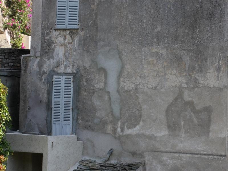 Кап-Корс, Корсика, 2008: стена с облупившейся штукатуркой и серыми жалюзи