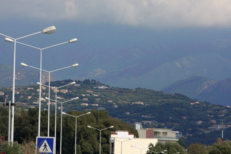 Ajaccio, 2008: уличные фонари и холмы с домами под туманным небом