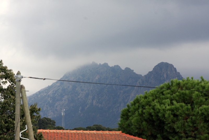 Ajaccio, 2008: туман над скалистым хребтом за красной черепицей
