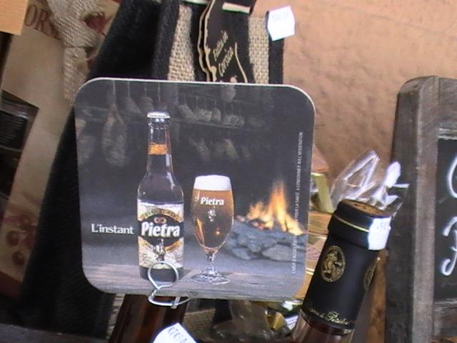 Ajaccio, 2008: табличка с бутылкой Pietra и стаканом у камина