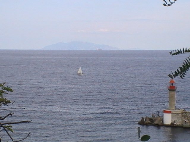 Ajaccio, 2008: белый парус у горизонта, фонарь на каменном пирсе