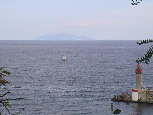 Ajaccio, 2008: белый парус у горизонта, фонарь на каменном пирсе