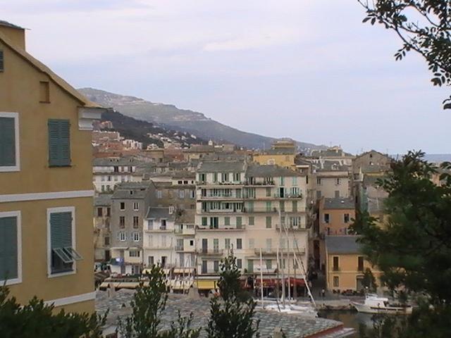 Ajaccio, 2008: старинные дома у набережной с мачтами яхт и холмом вдали