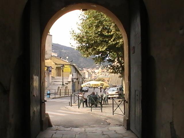 Ajaccio, 2008: арка ведёт в улочку с желтыми домами и зонтом