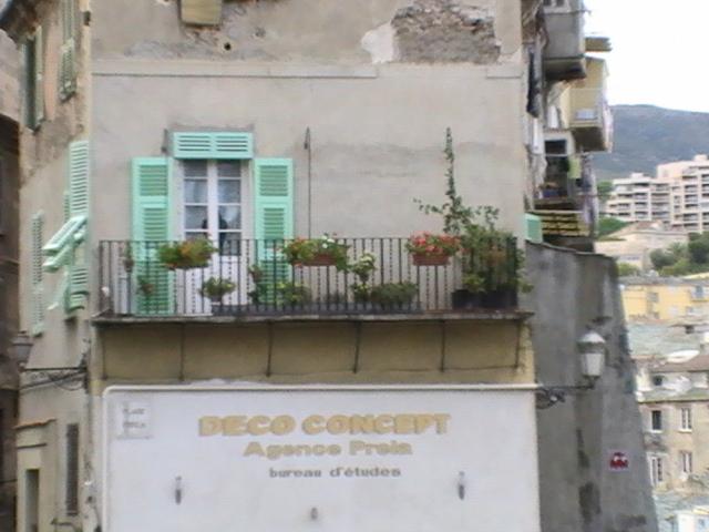 Ajaccio, 2008: балкон с зеленью и вывеской 'DECO CONCEPT' на фасаде старого дома