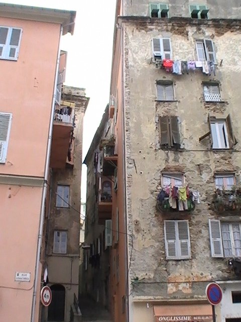 Ajaccio, 2008: узкий переулок между обветшалыми домами с бельём на балконах